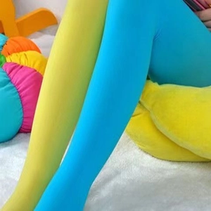 Détail du collant asymétrique en velours couleurs bonbon en bleu et vert citron