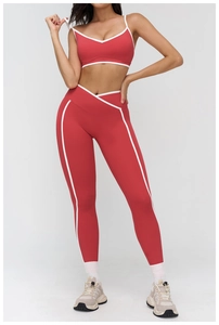 Detail of brick red yoga set showing white contrast piping and v-neck sports bra