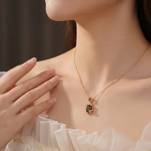 Elegant gold plated butterfly necklace with green zircon pendant shown on model