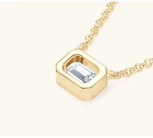 Macro view of square emerald-cut clear gemstone pendant on fine gold chain