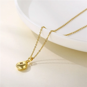 Minimalist gold teardrop necklace with starburst engraving and zircon on a fine link chain