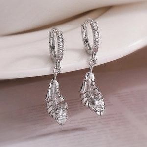 Elegant gold plated feather earrings with sparkling zircon crystals on white background