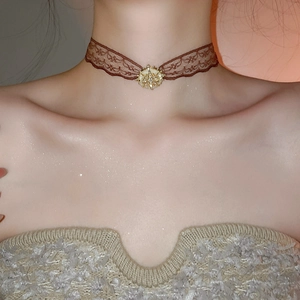 Close-up of brown lace choker with golden sunflower pendant and pearl detail