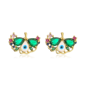 Macro shot of evil eye stud earrings with green teardrop stones and colorful crystals