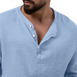 Close-up of light blue men's henley shirt showing textured cotton linen fabric and buttons