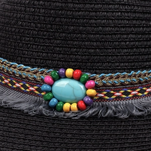 Detail of bohemian black straw hat featuring turquoise stone and colorful beadwork