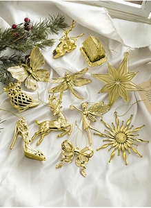 Detail of golden Christmas ornaments including reindeer and snowflakes on white satin