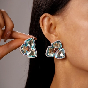 Elegant vintage-style blue crystal flower stud earrings with detailed braided gold edging