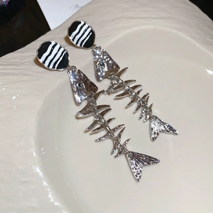 Detailed close-up of fishbone drop earrings with black and white striped enamel stud