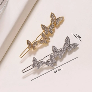 Detail view of gold and silver butterfly hair clips with sparkling rhinestone inlay
