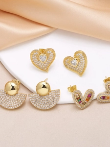 Detailed close-up of gold-plated heart and fan-shaped earrings with colorful zircons