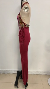 Detail of red halter evening dress featuring sequin floral embroidery and mesh paneling
