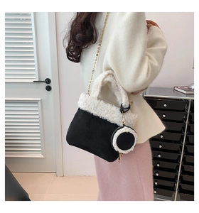 Detail of faux suede handbag with plush wool trim and gold chain on a model