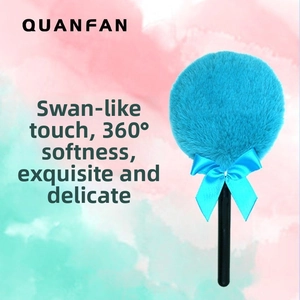 Detailed view of the soft fluffy cyan powder puff with a satin bow and slim handle