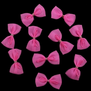 10er Set rosa Netz-Schleifen für Puppen und Haarspangen auf einem schwarzen Hintergrund