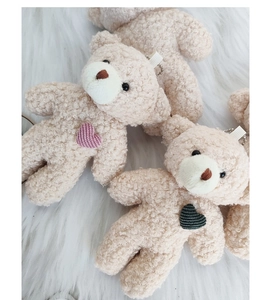 Detail of plush bear keychains with pearl fleece texture and heart patches