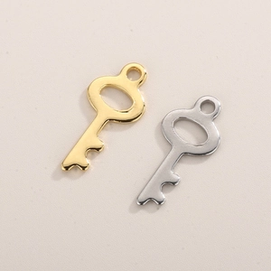 Macro detail of polished gold and silver hollow key charms for DIY jewelry making