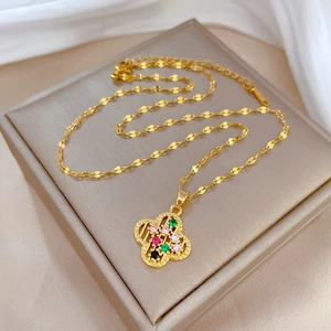 Luxurious gold clover necklace with colorful stones on an elegant jewelry box display