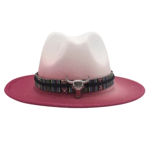 Detail of western fedora featuring colorful woven band and vintage metal bull head charm