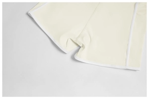 Detail of cream yoga shorts showing contrast white piping and reinforced ergonomic stitching