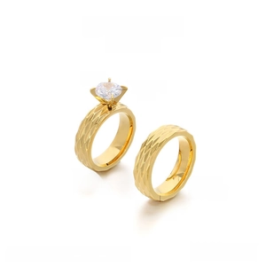 Detailed view of 6mm stainless steel couple rings with diamond-cut rhic-pattern and 18K gold finish