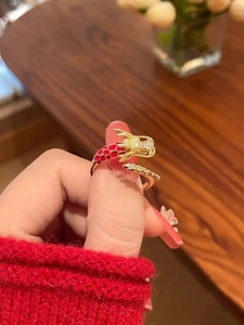 Detalle del anillo de dragón bañado en oro 18K con escamas de esmalte rojo y circonitas