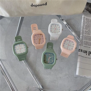 Square digital watch set in pastel colors with silicone straps on a stylish desktop