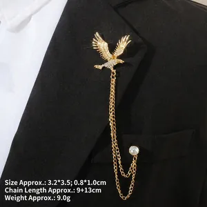 Détail d'une broche aigle dorée avec zircon et chaînes à glands sur revers noir