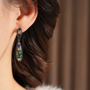 Détail de boucles d'oreilles vintage en forme de goutte avec zircons colorés