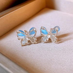 Gros plan de boucles d'oreilles papillon avec ailes d'opale bleue et détail en zircon