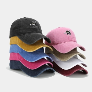 Détail montrant divers coloris de casquettes en coton délavé avec broderie de chat