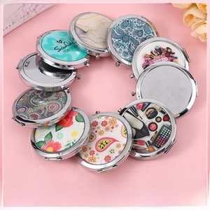 Detailed close-up of multiple compact folding mirrors with floral patterns and metal frames