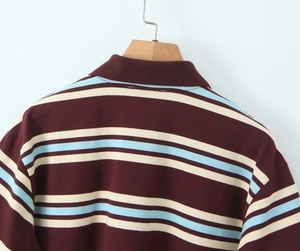 Macro detail of striped piqué polo fabric with precise stitching and ribbed collar texture