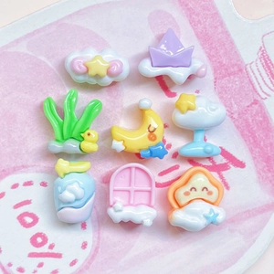 Detailed view of pastel resin charms in shapes of stars, clouds, and ducks for DIY crafts