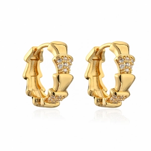 Gold plated cubic zirconia hoop earrings with wavy design on a white background