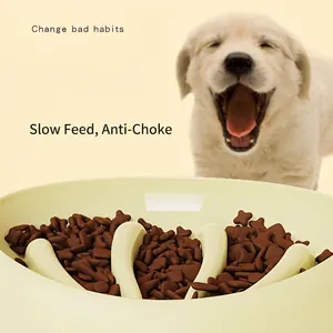 Beige pet slow feeder bowl for dogs with dry food and a golden puppy in background