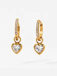 Close-up of golden hoop earrings featuring zircon studs and heart-shaped crystals