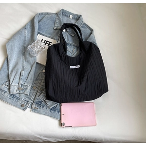 Lifestyle-Foto einer schwarzen Tragetasche mit KISS YOURSELF Label und Freizeitaccessoires