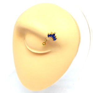 Detail of curved gold eyebrow barbell with five marquise-cut blue stones on a model