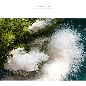 Macro detail of artificial white snow powder scattered on green pine needles for decor