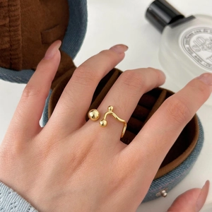 Minimalist S925 sterling silver golden bead ring worn by model with jewelry box