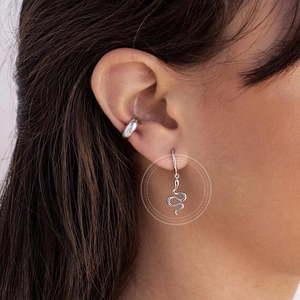 Silver snake drop earrings with minimalist cuffs worn on model in a stylish side view
