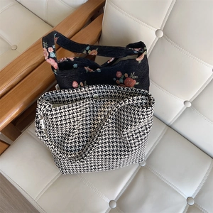 Detailed close-up of floral embroidery and houndstooth pattern fabric bags with magnetic buckle
