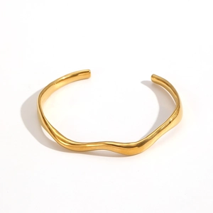 Detail of 18k gold plated stainless steel bangle with a wavy irregular open design