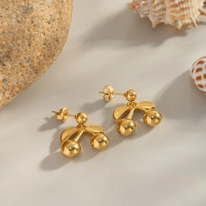 Detailed view of 18K gold cherry stud earrings with a polished finish and metal luster