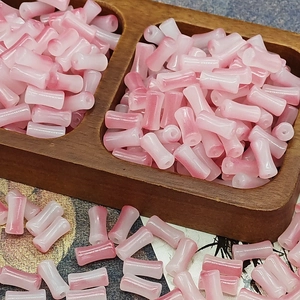 Macro detail of pink and white gradient bamboo shaped glass beads for DIY hair accessories