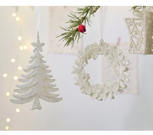 Detail of silver glittery Christmas tree and gift box ornaments with sparkling finish