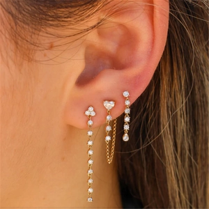 Close-up of a model wearing three golden S925 silver tassel earrings with clear zircons