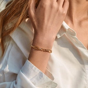 Fashionable 18K gold-plated brass chain bracelet worn on wrist with oval and twisted links