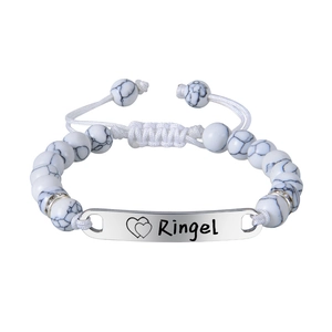 Détail du bracelet bébé avec perles en marbre blanc et plaque en acier gravée